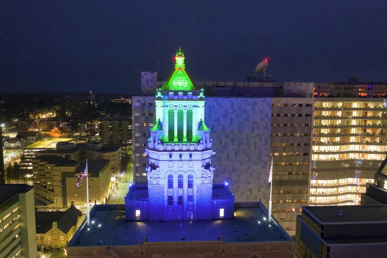 cityscape, including an old building, lit up in green and blue