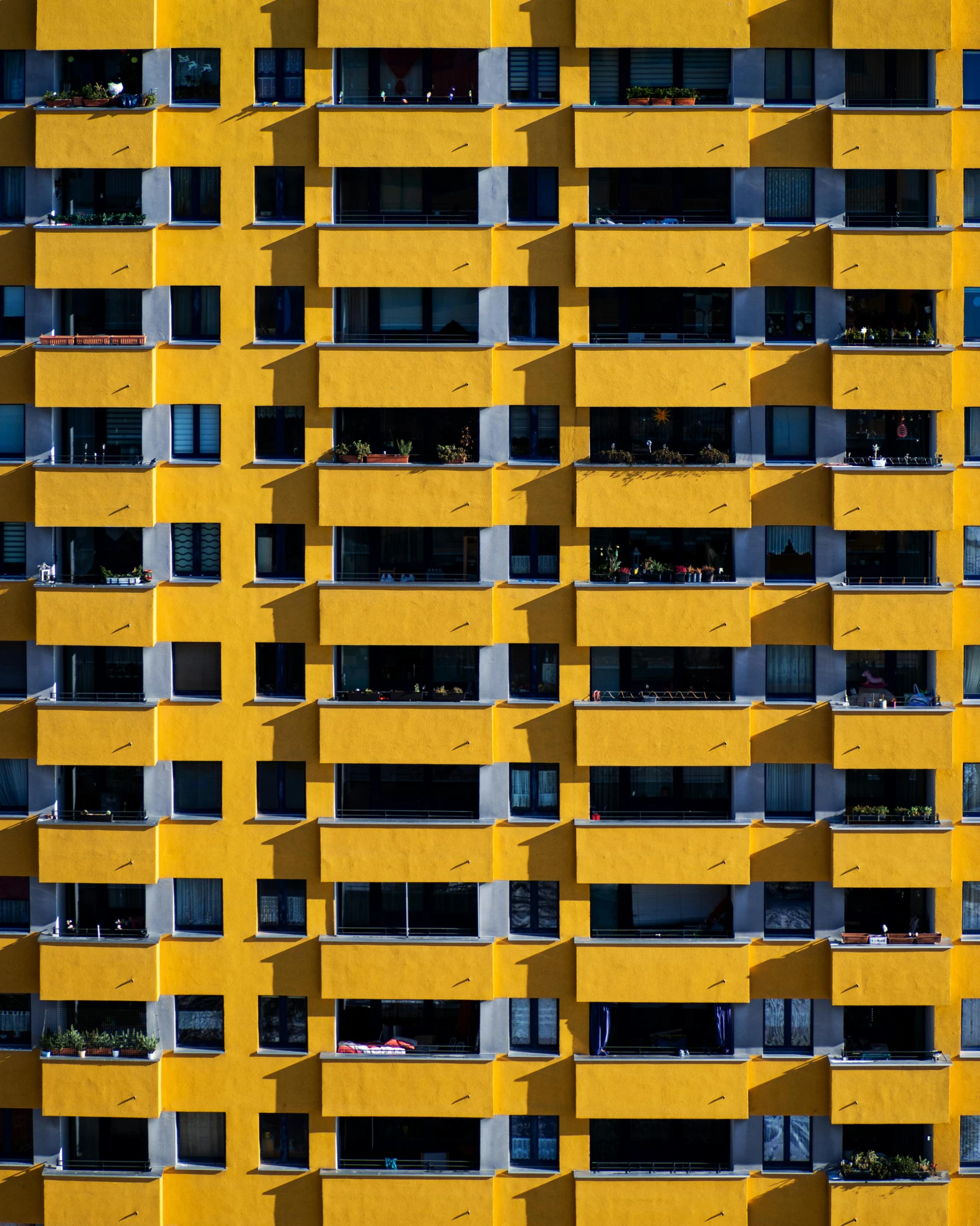 a building made up of yellow colored windows with white balconies