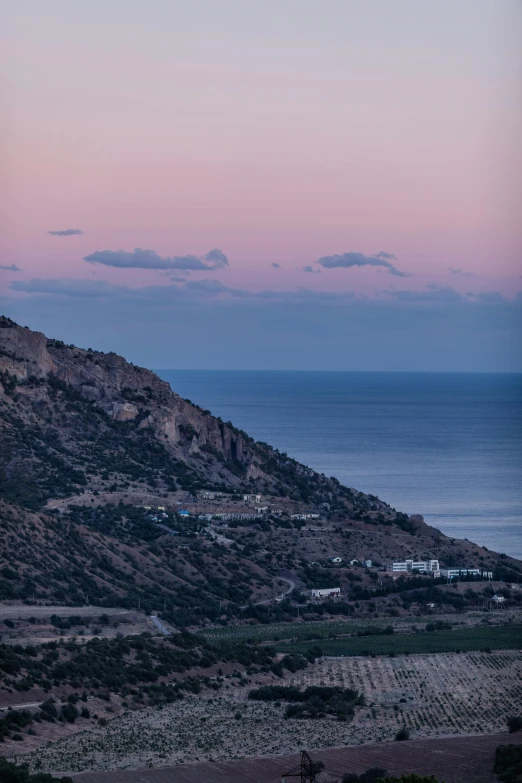 a view of the ocean from the top of a hill, unsplash, les nabis, dusk setting, costa blanca, pink, sleepy