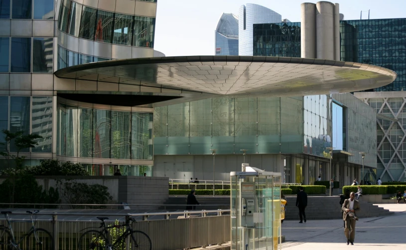 a walkway next to an intersection in front of a tall building