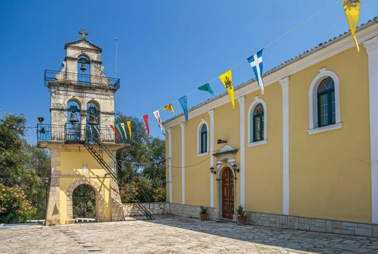 a yellow building with a clock tower in front of it, inspired by Antonín Chittussi, renaissance, meni chatzipanagiotou, ribbon chapel, tourism, profile image