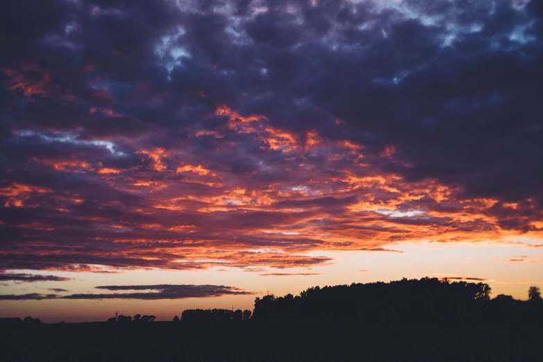 a sunset with clouds and trees in the background, pexels contest winner, purple orange colors, instagram post, big sky, red hues