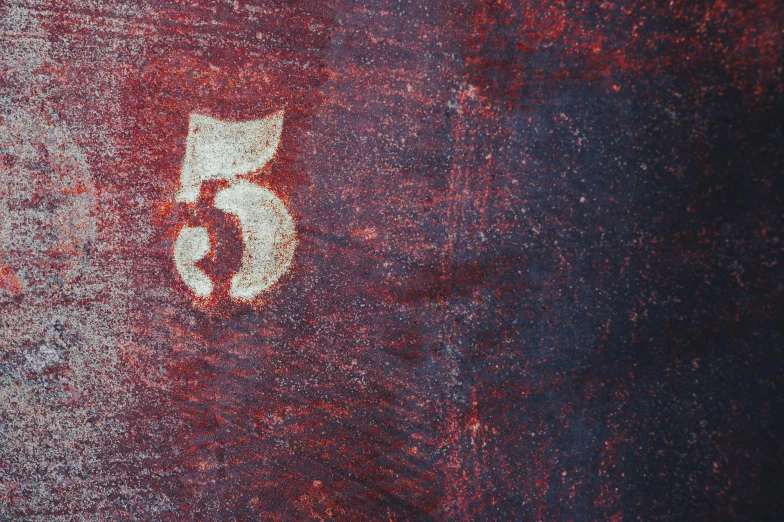 a close up of a number on a metal surface, by Julian Schnabel, unsplash, indigo and venetian red, five score years ago, cloth banners, muted colors. ue 5