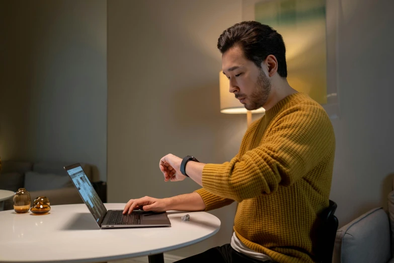 a man sitting at a table using a laptop computer, happening, wearing a watch, jesper esjing, home office, multiple stories