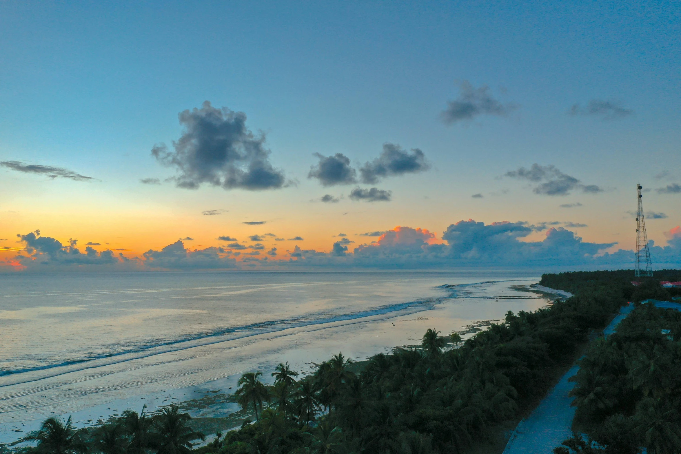 a beach at sunset, taken from a hill