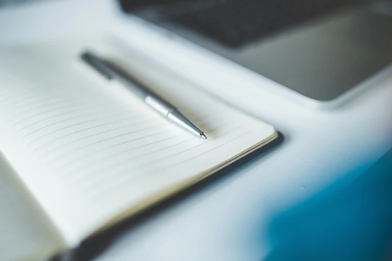 pen resting on notebook on desk during daylight