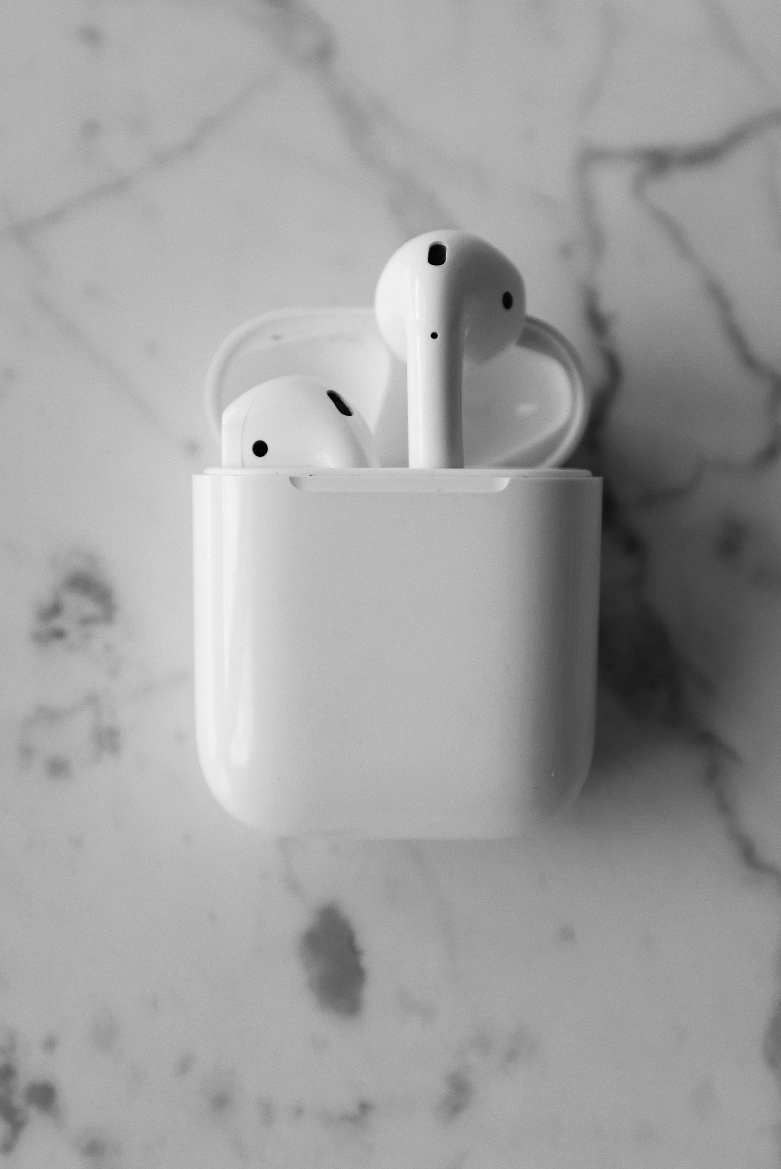 an apple airpods sitting on top of a marble counter, a black and white photo, by Robbie Trevino, pexels, made of glazed, square, ship, sport