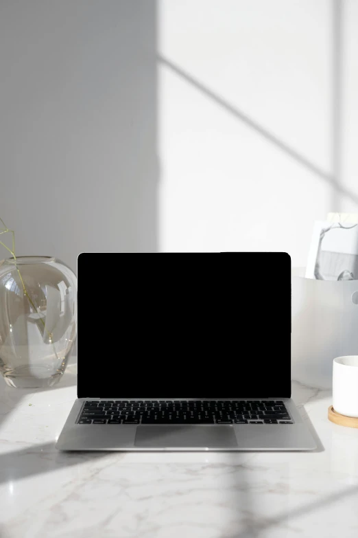 a laptop computer sitting on top of a white desk, by Robbie Trevino, light and space, vantablack, curated collections, morning sun, no people