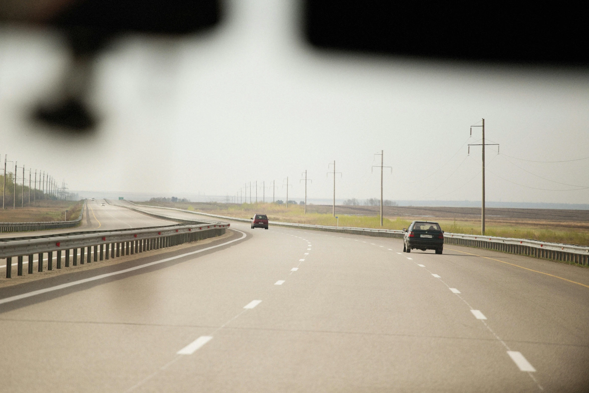 the rear view mirror has a reflection of a car on it