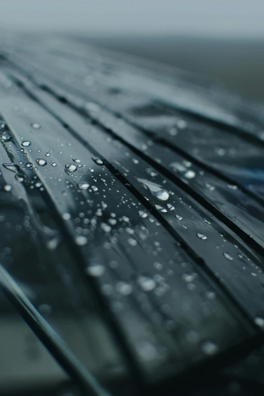 a close up of an umbrella with water droplets on it, a macro photograph, by Ryan Pancoast, unsplash, photorealism, coated pleats, carbon fibers, glass and metal : : peugot onyx, cinematic film still