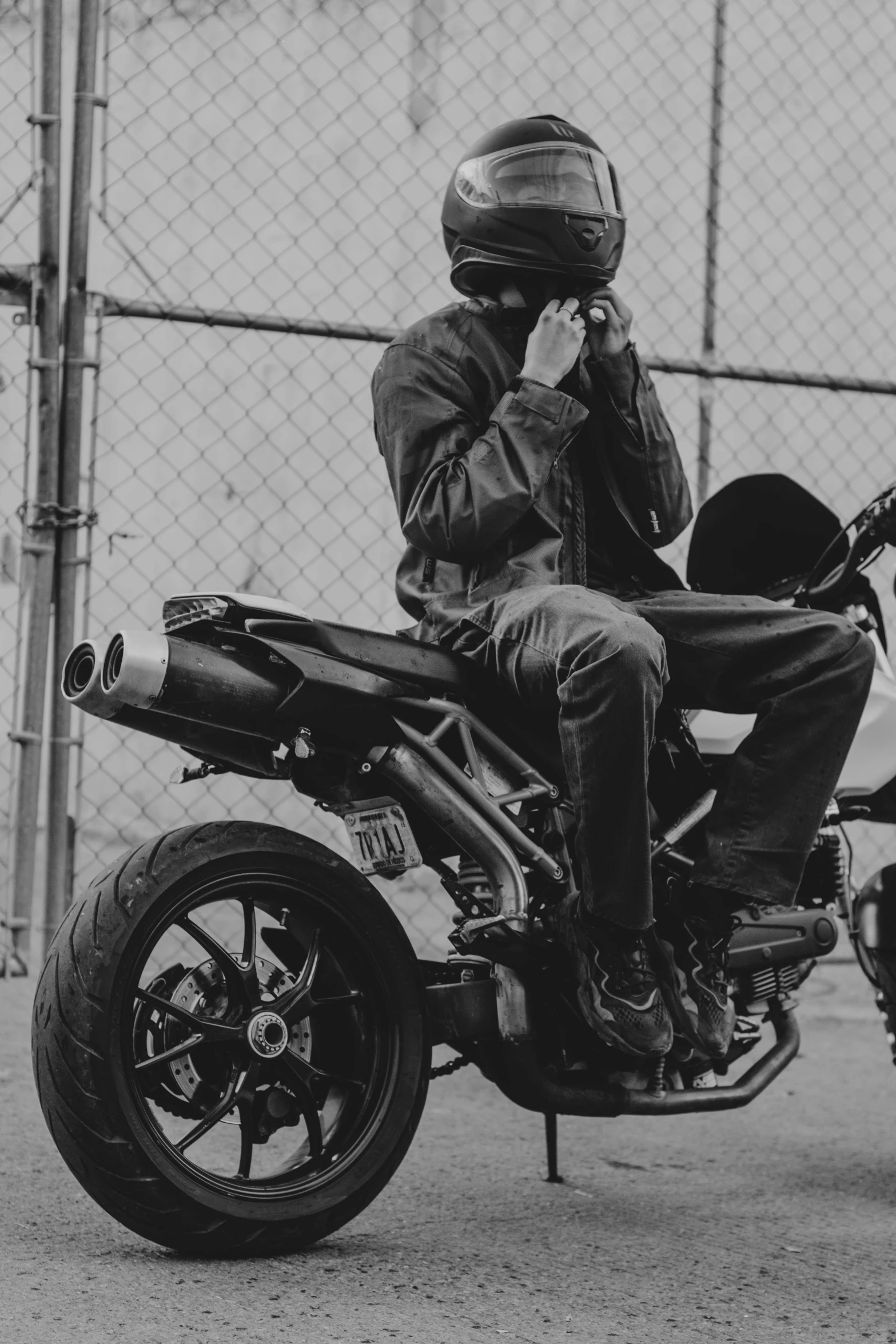 a man sitting on a motorcycle talking on a cell phone, a black and white photo, inspired by Cam Sykes, unsplash, tyler the creator, techwear fashion, black man, album art young thug