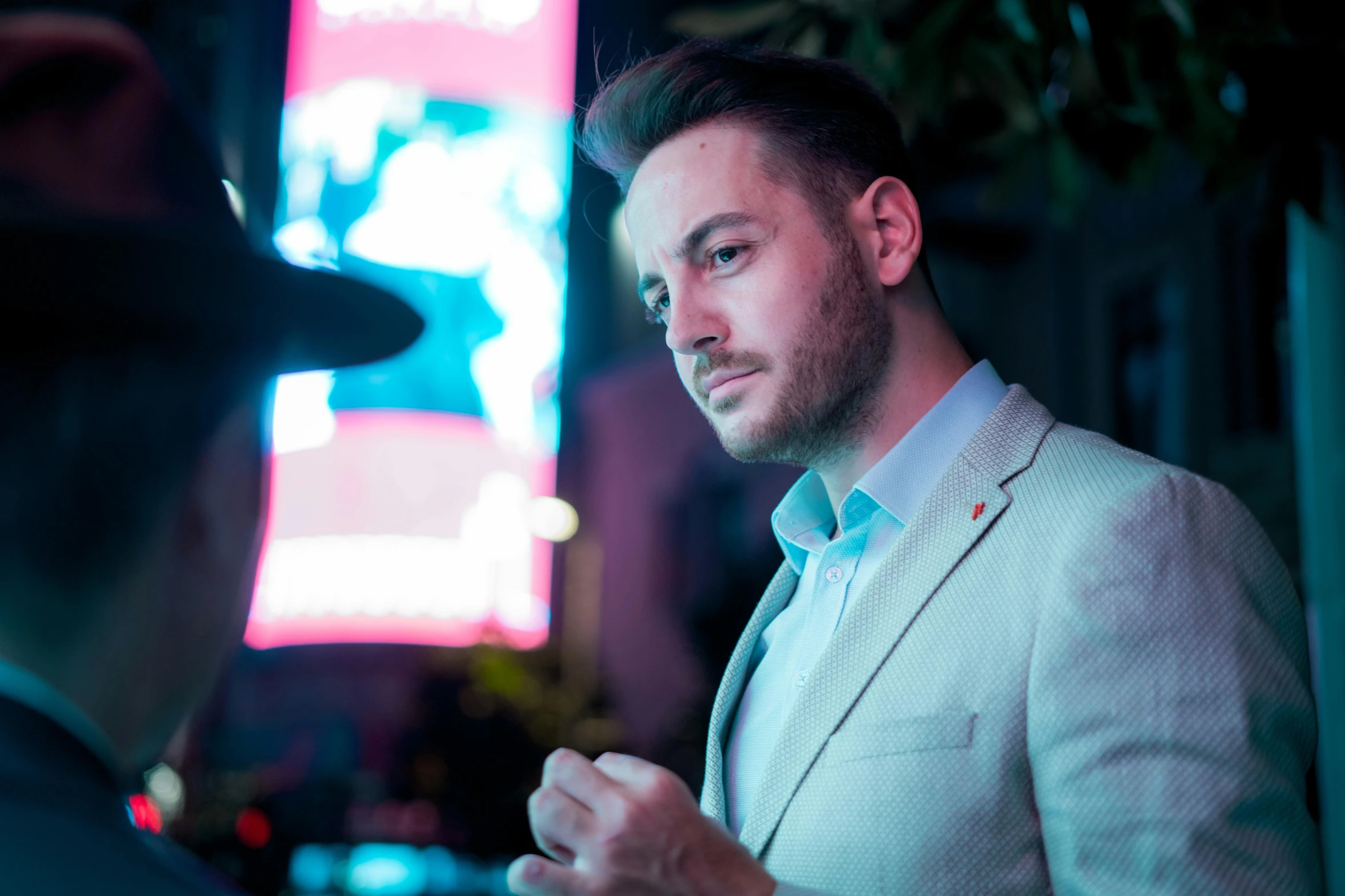 a man talks with another person next to a tall building