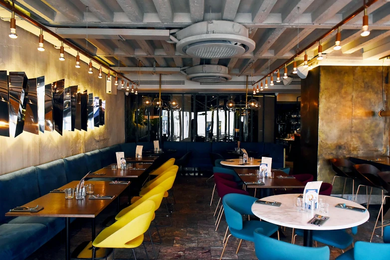 a restaurant is set up with wooden tables and blue booths