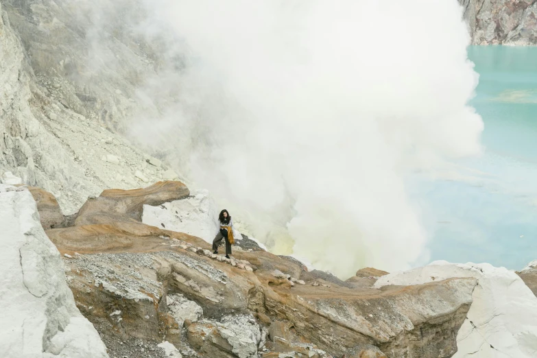 there are two people standing on the side of a cliff