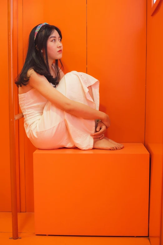 a woman in a white dress sitting on an orange bench, an album cover, inspired by Ren Hang, flickr, in an elevator, 奈良美智, capsule hotel, ron mueck