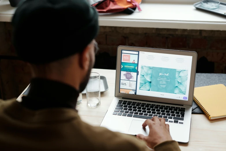 a man sitting in front of a laptop computer, a screenshot, by Julia Pishtar, trending on unsplash, islamic, 9 9 designs, print ready, close up to the screen