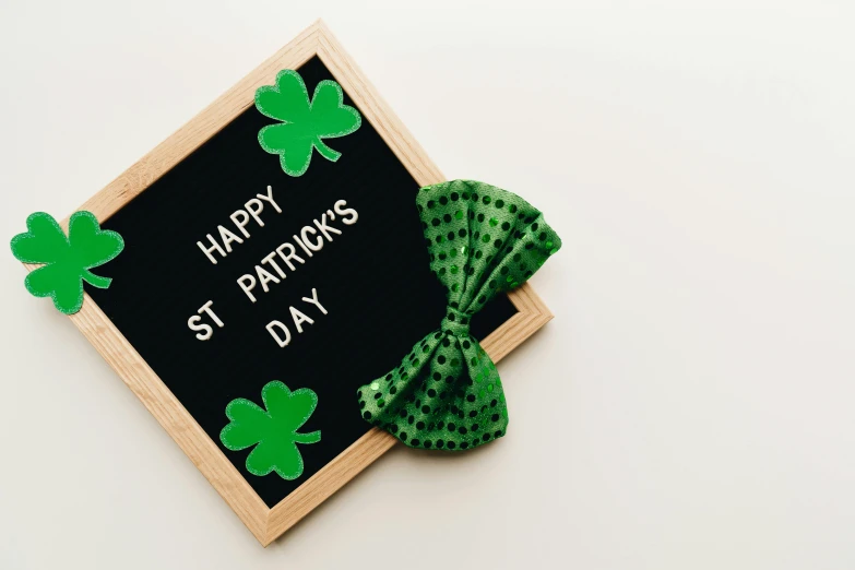 a sign that says happy st patrick's day with a green bow tie, pexels contest winner, hurufiyya, blackboard, 1 6 x 1 6, sustainable materials, set against a white background