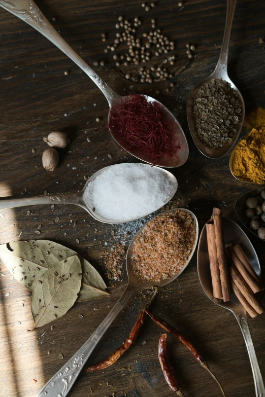 a table topped with spoons filled with different types of spices, a still life, trending on pexels, renaissance, half image, thumbnail, 8 l, opening shot