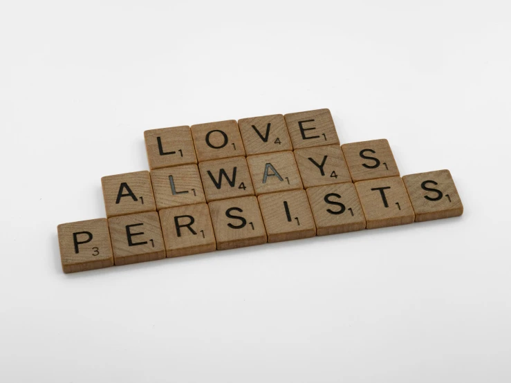 a scrabble that says love always persiss, letterism, 35 mm product photo”, alchemist, 144p, posed