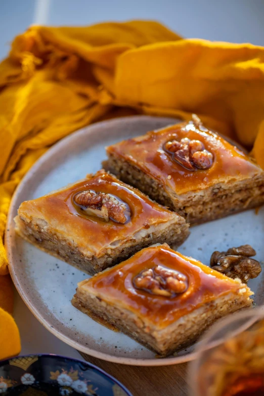 a close up of a plate of food on a table, pastry, squares, puṣkaracūḍa, pumpkin