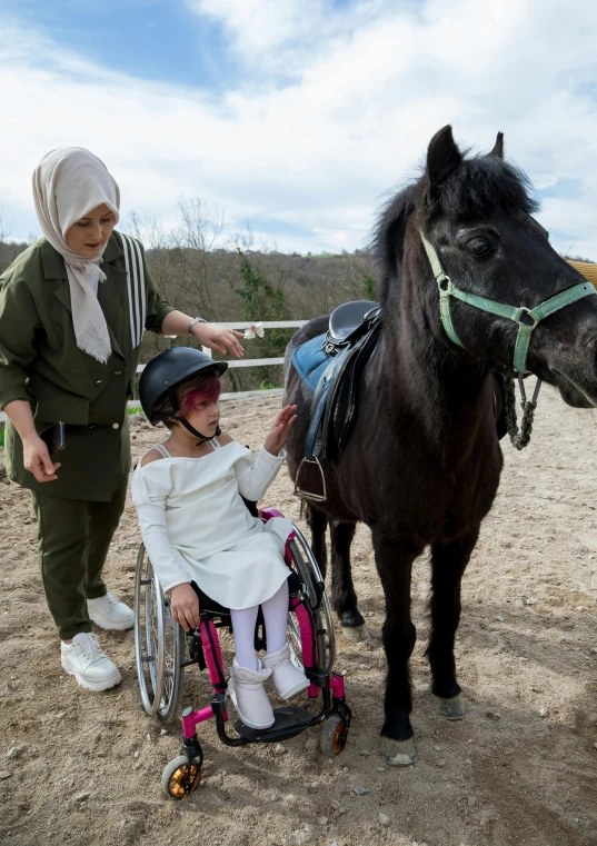 a woman in a wheel chair petting a horse, hurufiyya, hijab, slide show, 2019 trending photo, kids