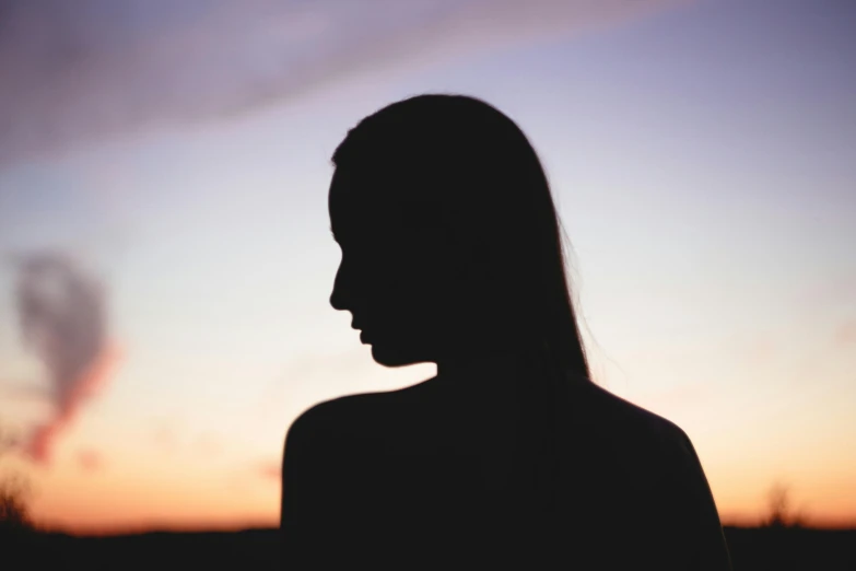 a silhouette of a woman standing in front of a sunset, smooth chin, photo of a woman, human staring blankly ahead, face partially obscured