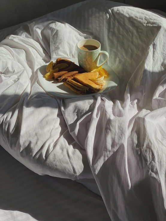 a plate of cookies and a cup of coffee on a bed, by Rebecca Horn, unsplash contest winner, hyperrealism, white sheets, joel meyerowitz, detail shot, sunlight