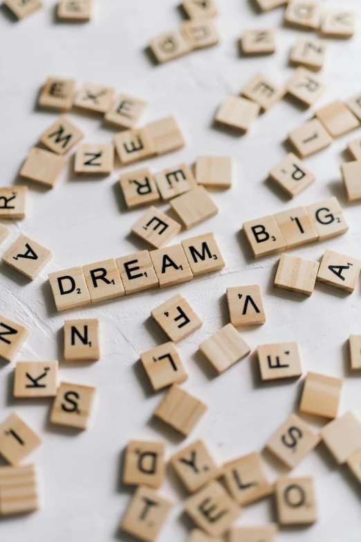 a pile of scrabbles sitting on top of a table, a picture, by Judith Gutierrez, unsplash, dream like, you may say i'm a dreamer, seeds, thumbnail