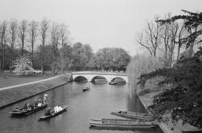 a black and white photo of several boats on a river, a black and white photo, inspired by Richmond Barthé, stone bridge, court archive images, parks and gardens, vintage 1960 print