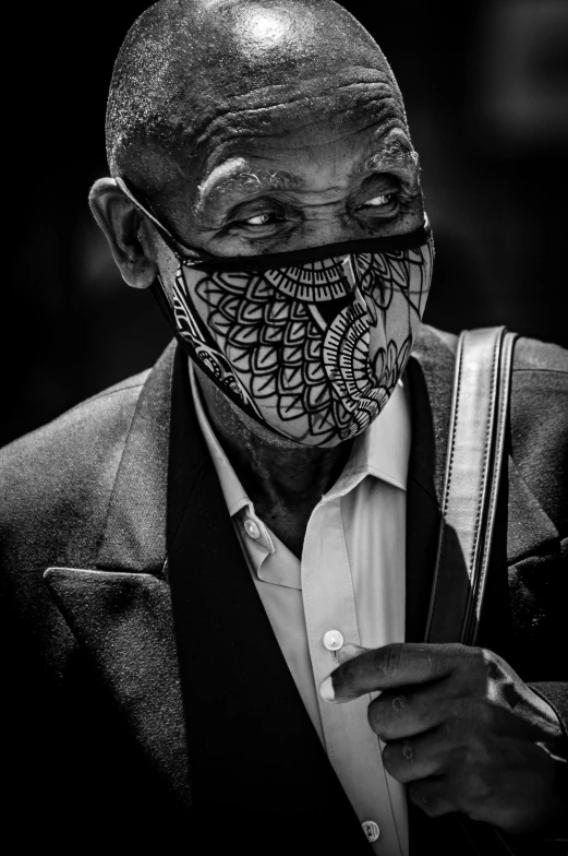 a black and white photo of a man wearing a face mask, a black and white photo, inspired by Candido Bido, vibrant patterns, street life, intricate ink, serious business