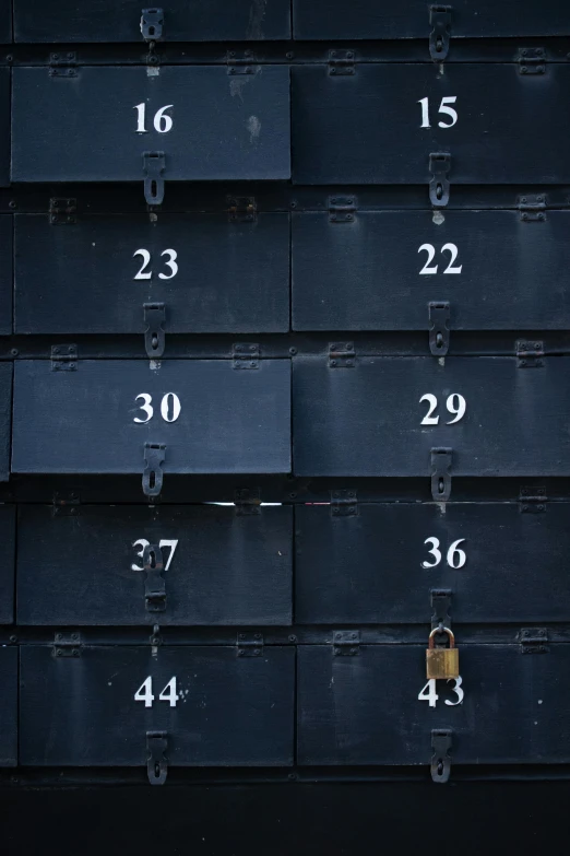 a red fire hydrant sitting in front of a bunch of mail boxes, an album cover, by Andries Stock, unsplash, black and blue, lockers, sacred numbers, on a black wall