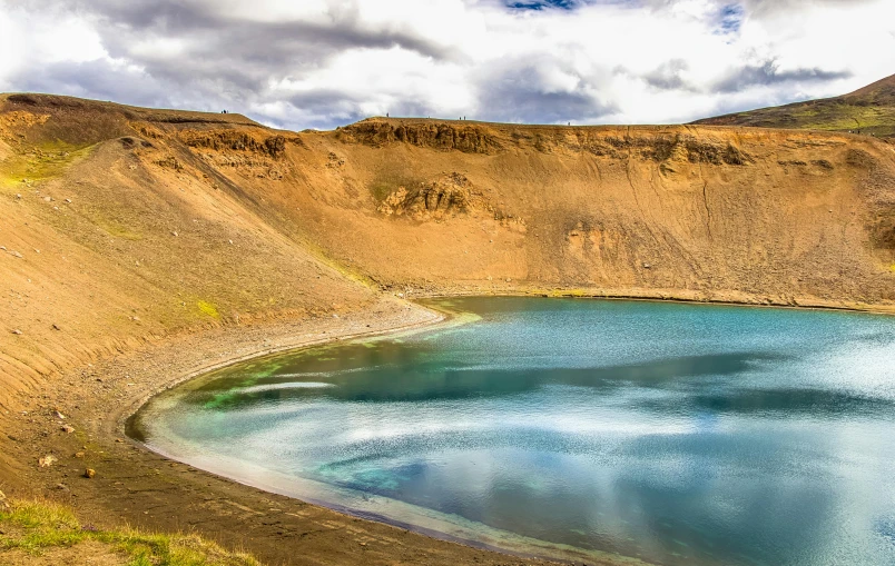 an area with sand, water and grass