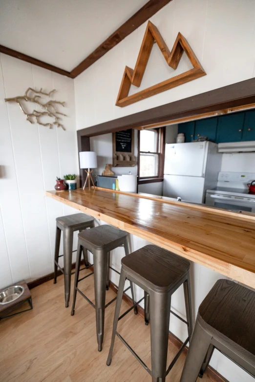 an empty bar with metal stools and a microwave