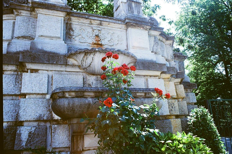 a stone fountain is decorated with a flower on it