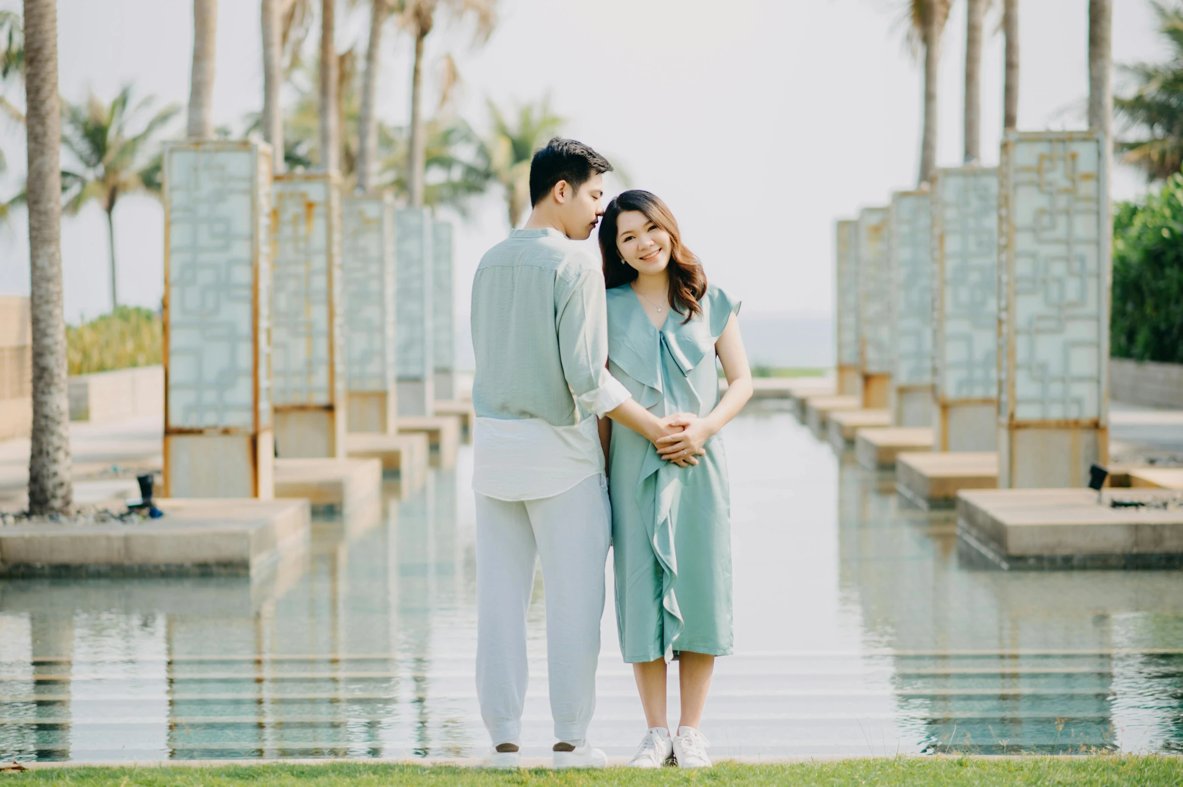 a man and a woman standing next to each other, a picture, pexels contest winner, happening, sea - green and white clothes, avatar image, asian female, pregnancy