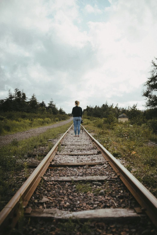 a person standing on a train track in the middle of nowhere, by Lucia Peka, unsplash, lynn skordal, multiple stories, a wooden, 3 5 mm slide