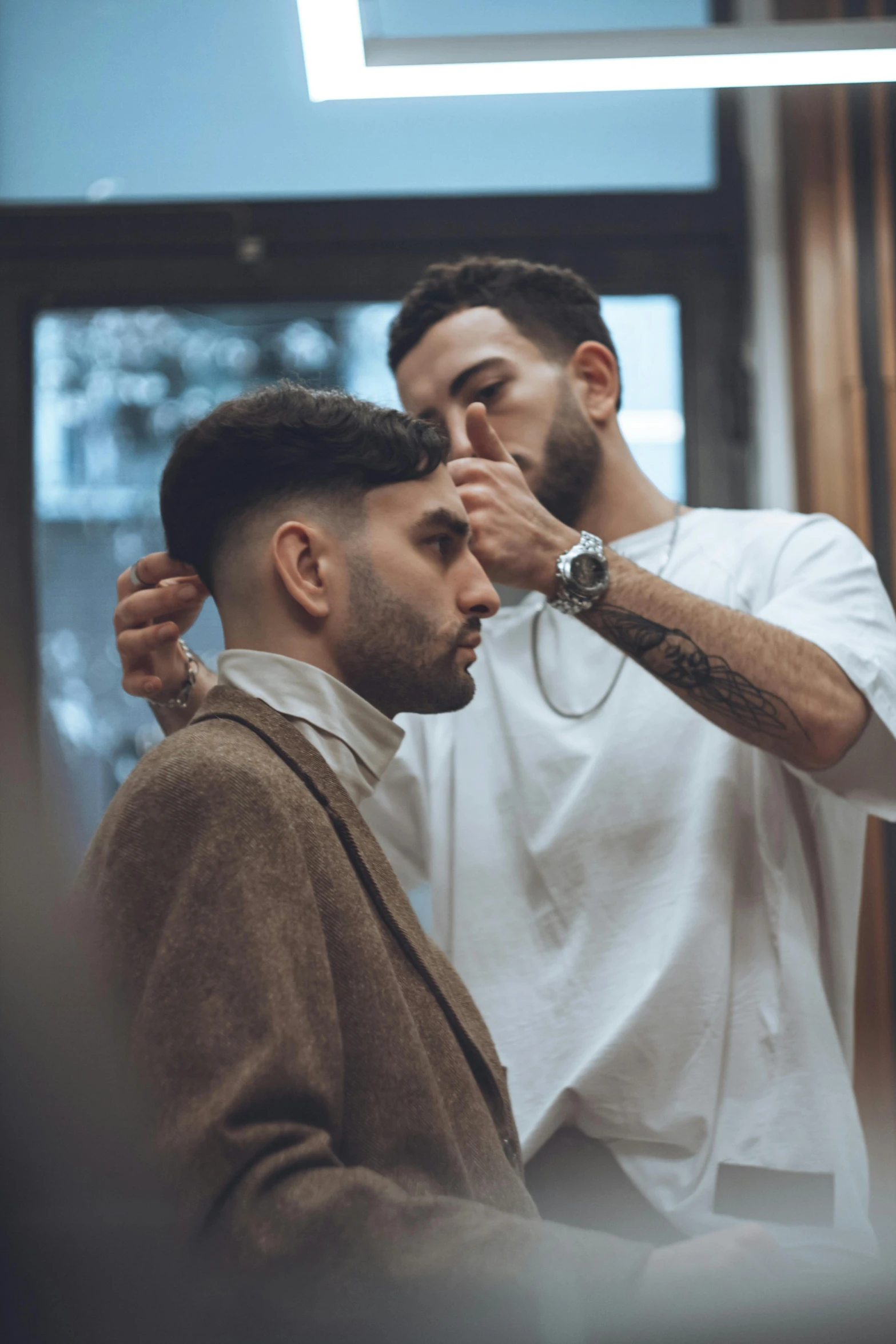 two men looking at each other getting ready for their haircut