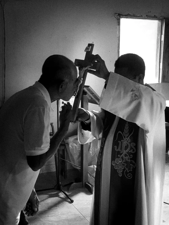 a black and white photo of a priest and a man, a photo, by Ingrida Kadaka, taking a picture, with a stethoscope, shot with iphone 1 0, a new