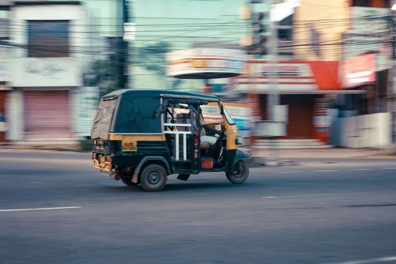 an old, black jeep drives down the street