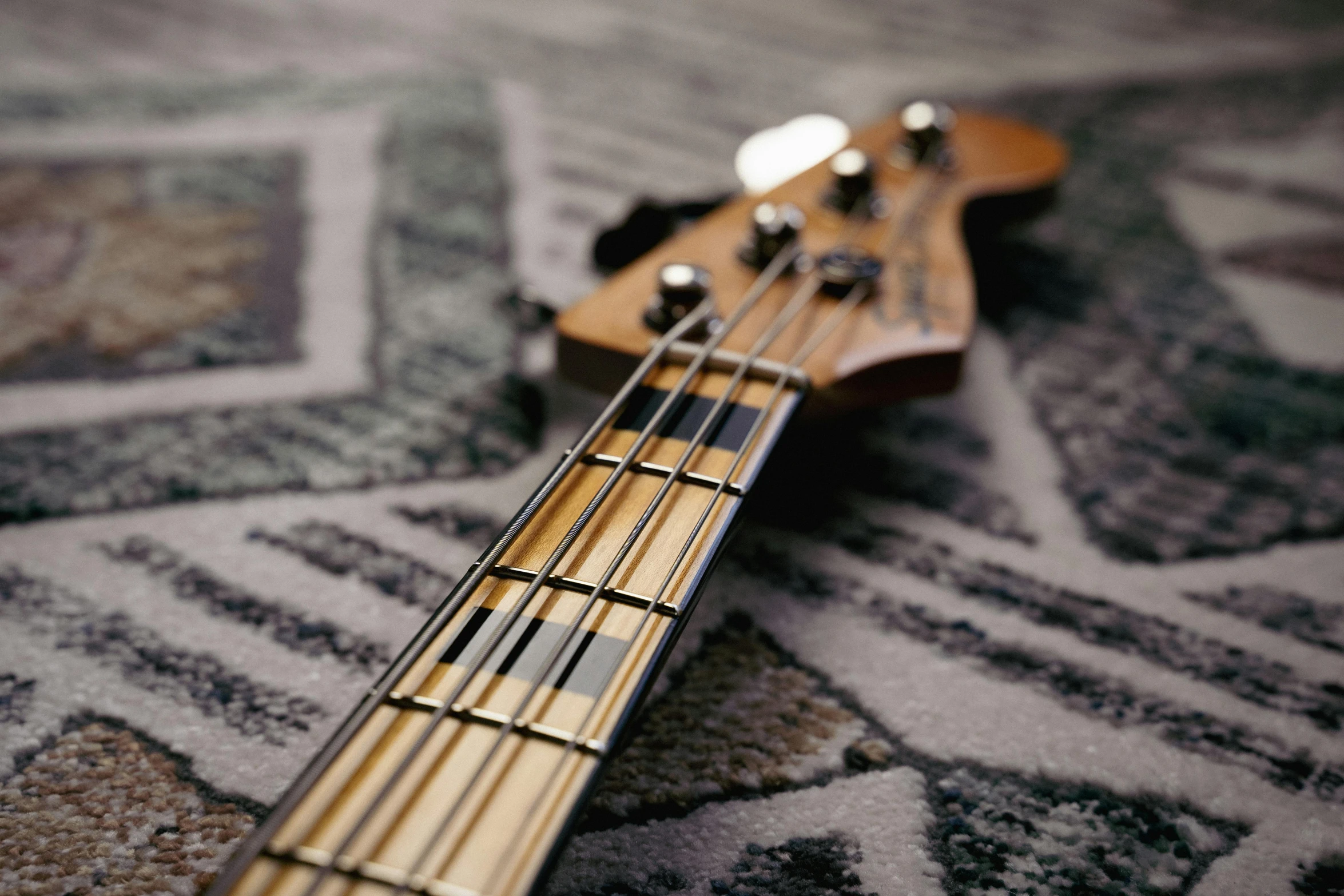 a close up of a bass guitar on a carpet, unsplash, photorealism, instagram picture, slightly tanned, shot on sony a 7, streamlined spines