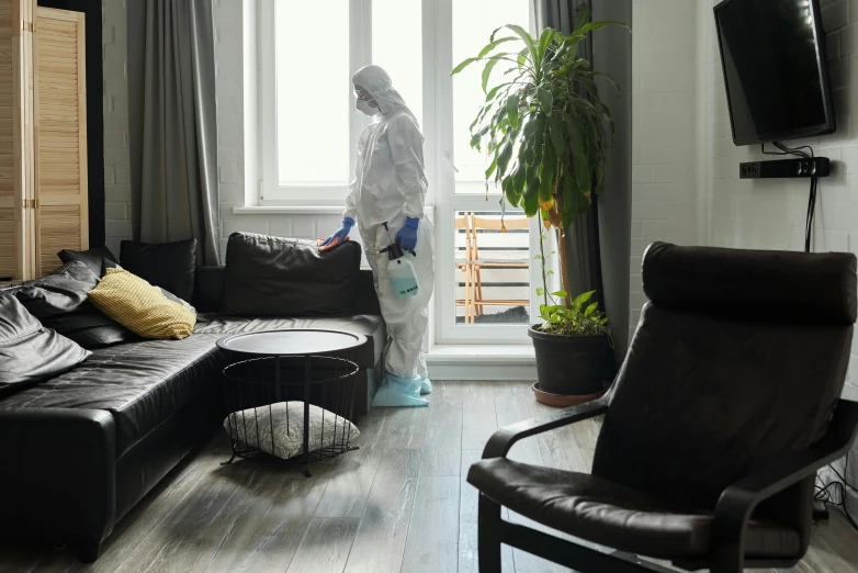 man in a protective suit standing in a living room