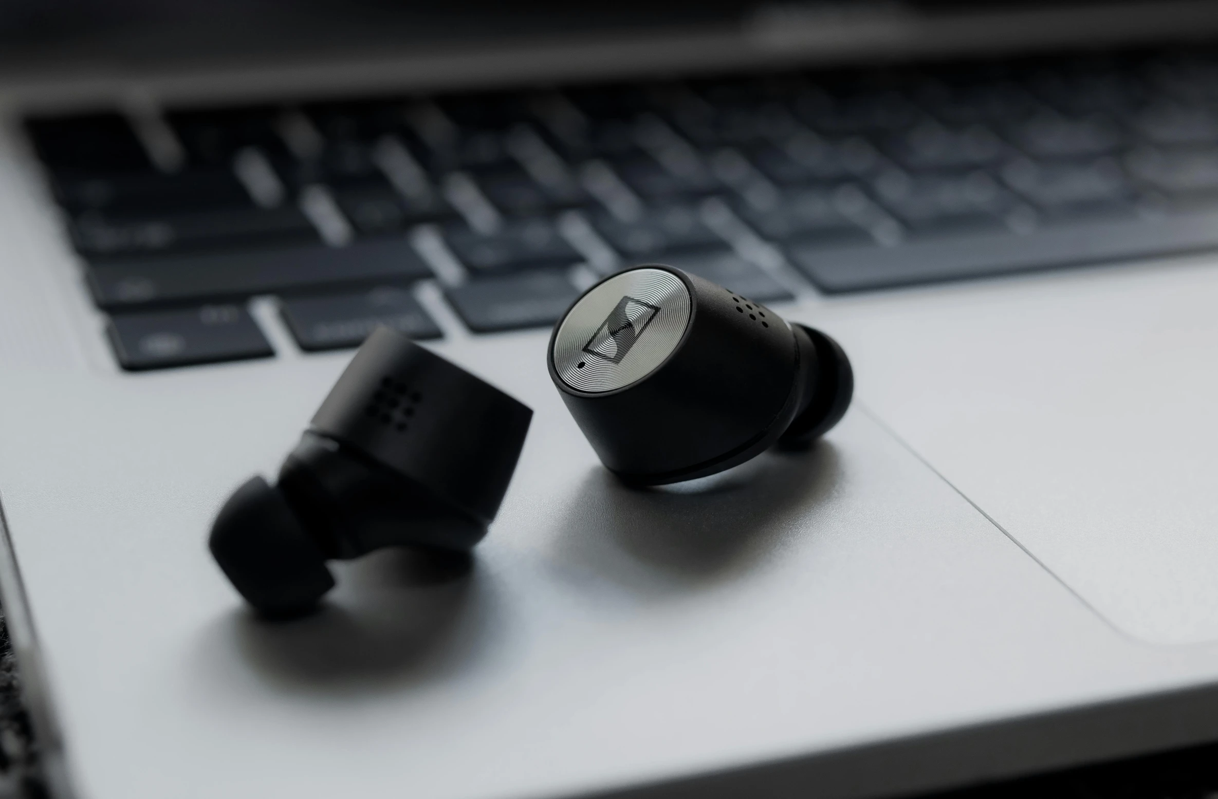 a pair of ear buds sitting on top of a laptop, unsplash, bauhaus, zig zag, black jewellery, highly technical, small in size