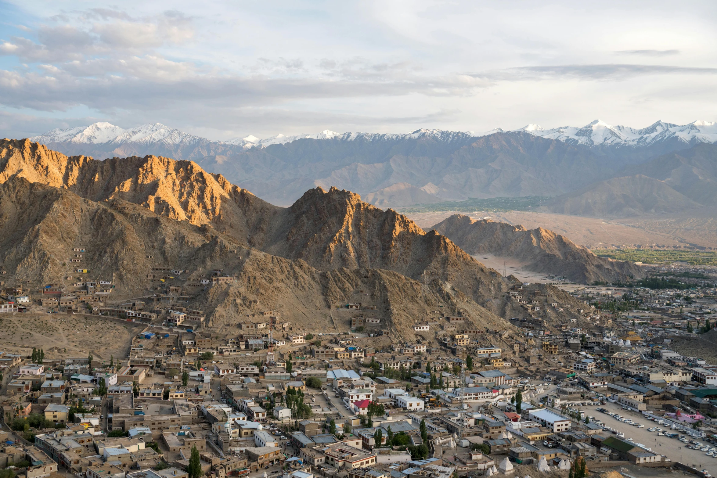 an aerial view of a mountain town with mountains in the background