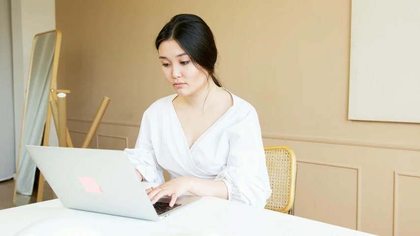 a woman sitting at a table using a laptop computer, a portrait, inspired by Ruth Jên, trending on pexels, wearing white silk robe, avatar image, korean woman, concentration