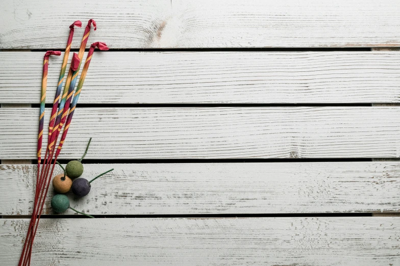 a bunch of sticks sitting on top of a wooden table, inspired by Ödön Márffy, unsplash, holding maracas, white plank siding, candies, rope