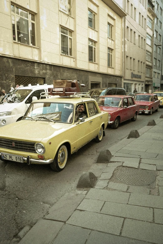 a group of cars parked on the side of a street, by Sven Erixson, renaissance, slovakia, restored color, gold, yellow