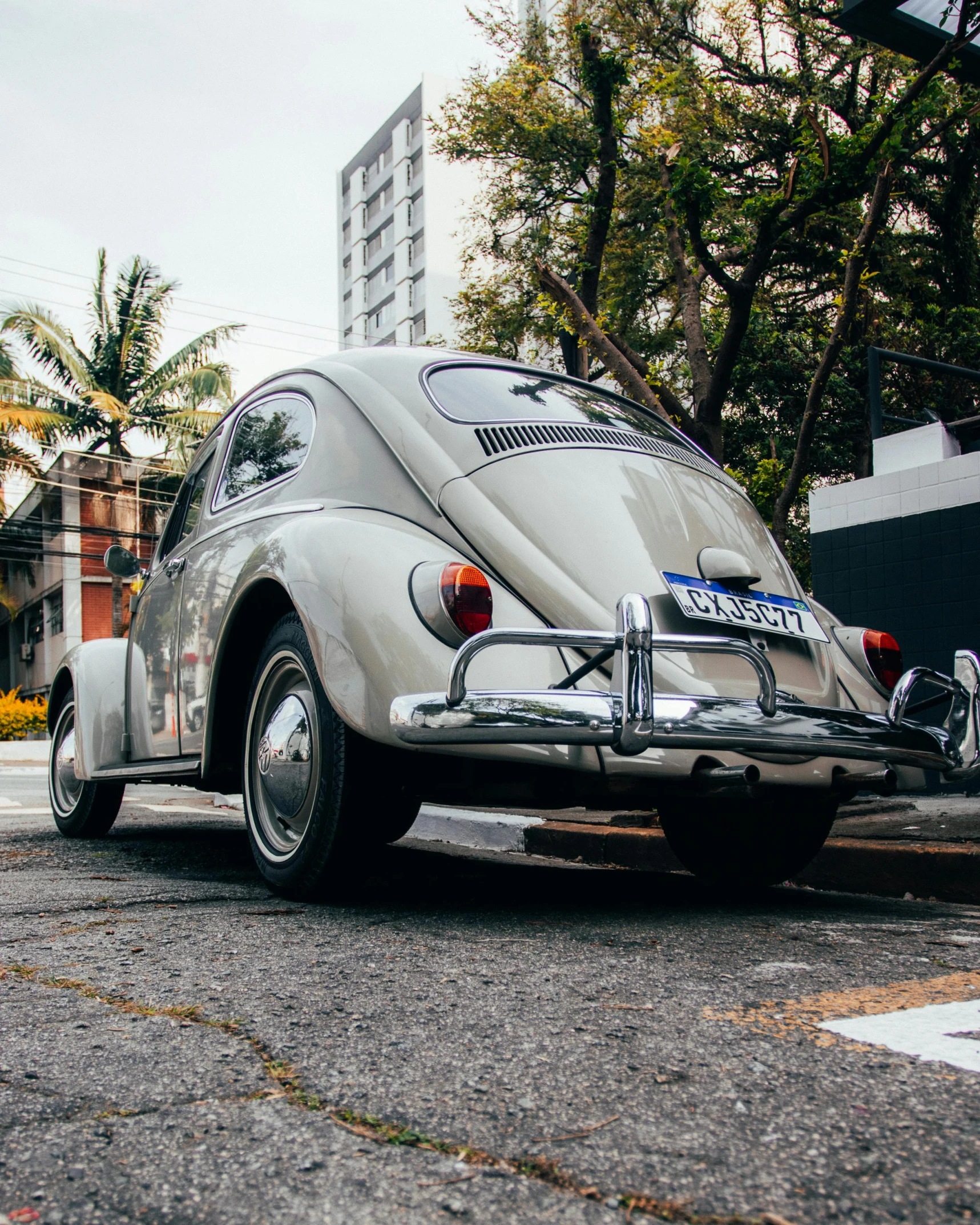 the large beige vw bug is parked on the side of the road