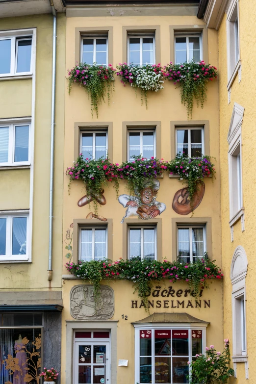 a building that has a bunch of flowers on it, by Karl Gerstner, pexels contest winner, beer, golden windows, bas relief, uncropped