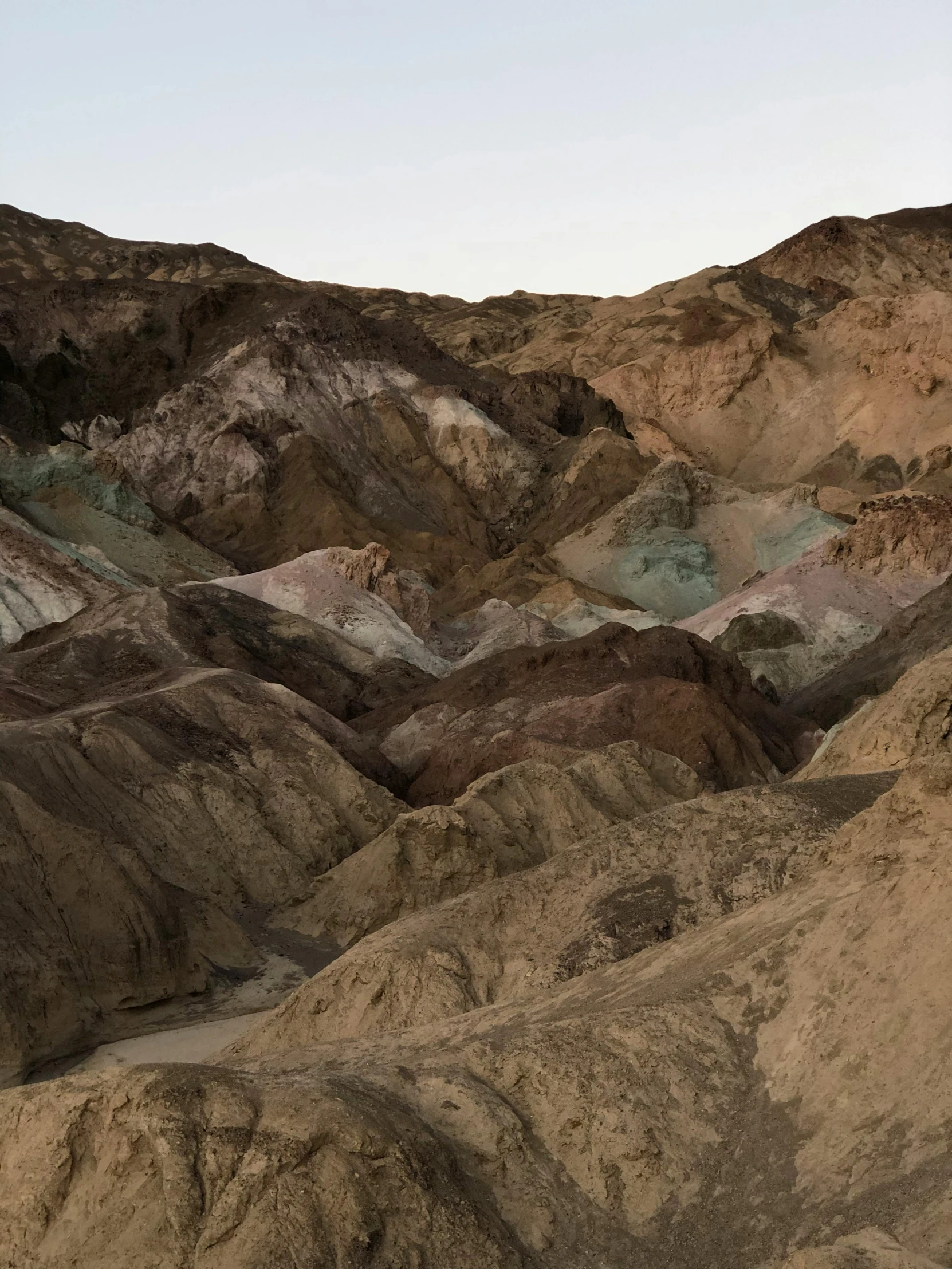 a mountain covered in rocks and dirt at dusk