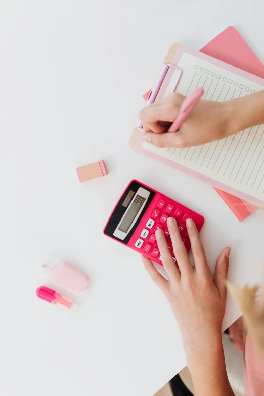 a woman sitting at a desk using a calculator, trending on pexels, 🎀 🍓 🧚, instagram post, top - down photograph, iconic scene